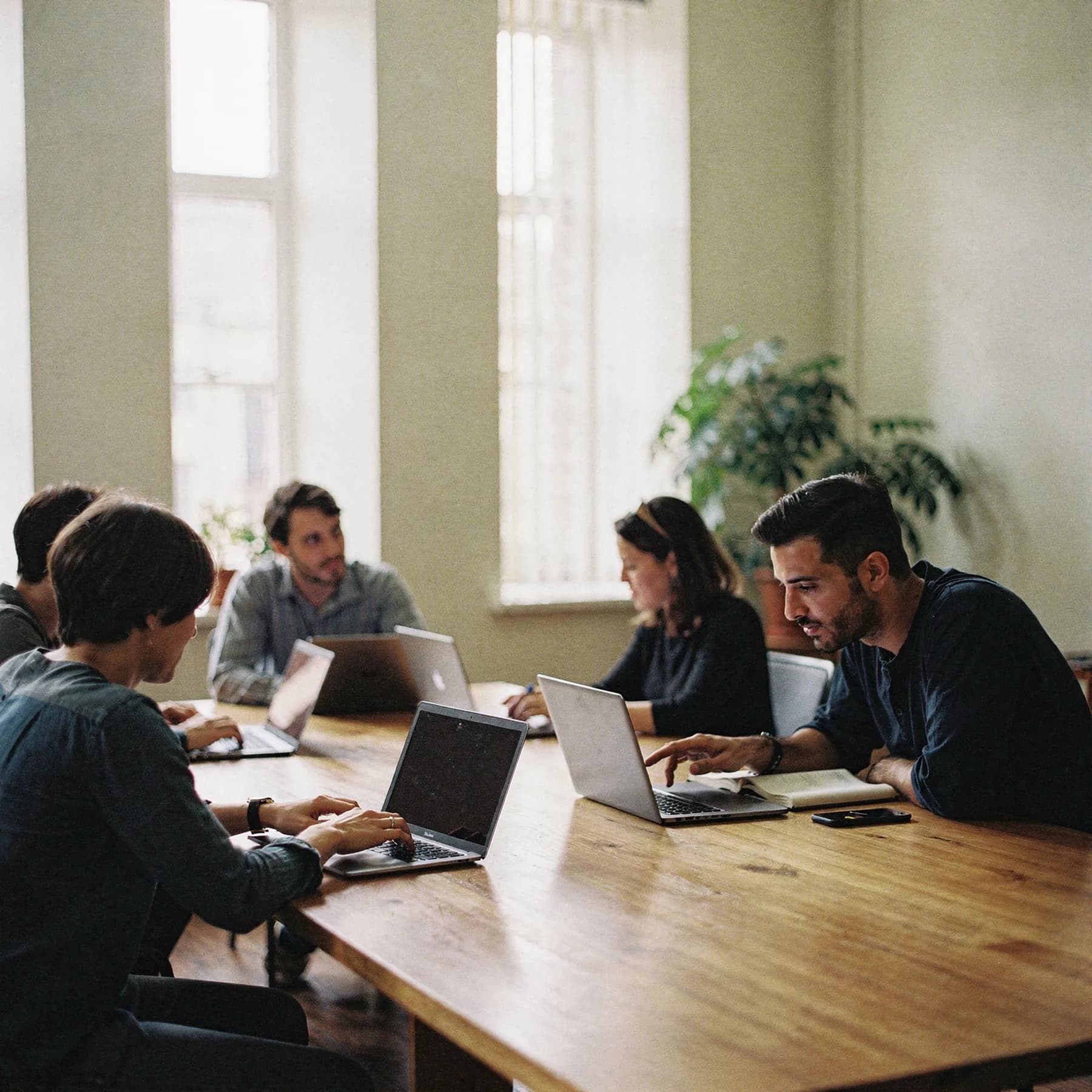 Dozent unterrichtet Teilnehmer der Triolo Bildungsakademie an Laptops im Schulungsraum